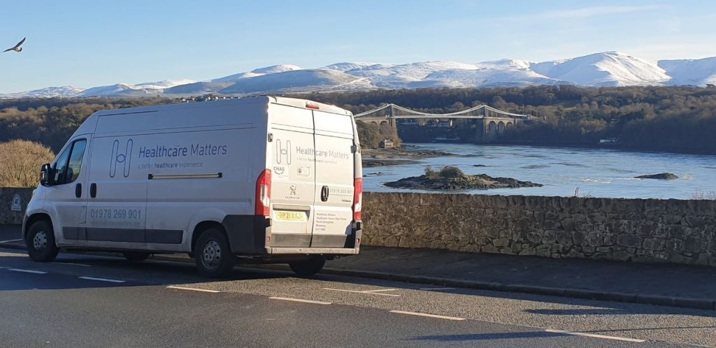 Healthcare Matters vehicle driving with mountains in the background